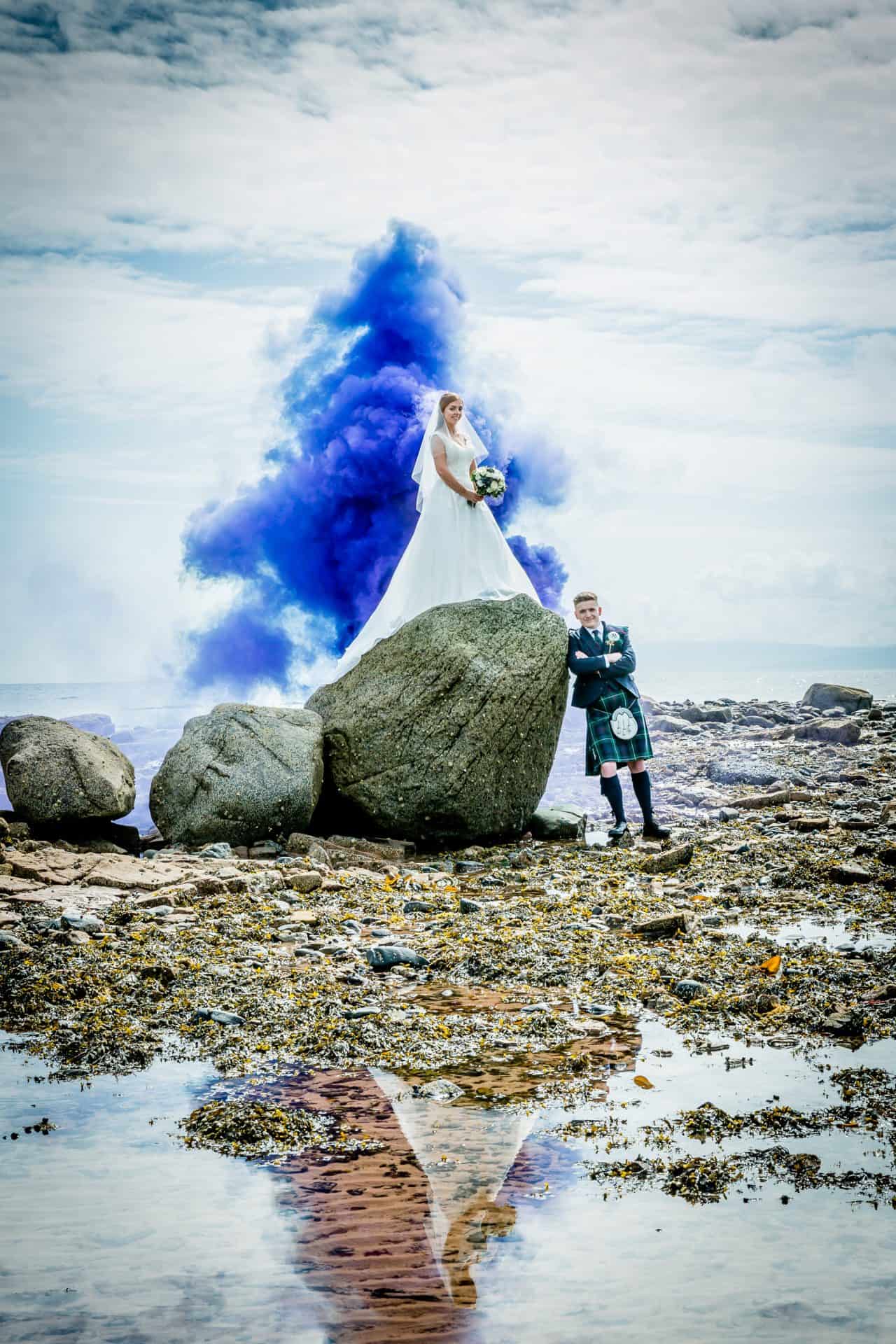Bride and groom with blue smoke on the beach at The Waterside Hotel & Spa, Ayrshire